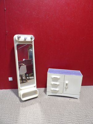 une petite commode blanche et un miroir dans une pièce