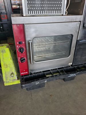 a silver oven sitting on top of a pallet in a warehouse