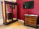 a dresser and a mirror in a room with a red wall