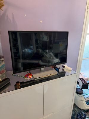 une télévision à écran plat posée sur un meuble blanc