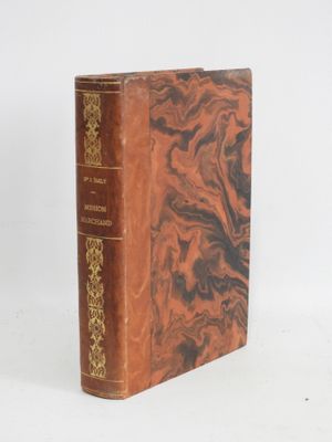 an old book sitting on top of a white table next to a white wall