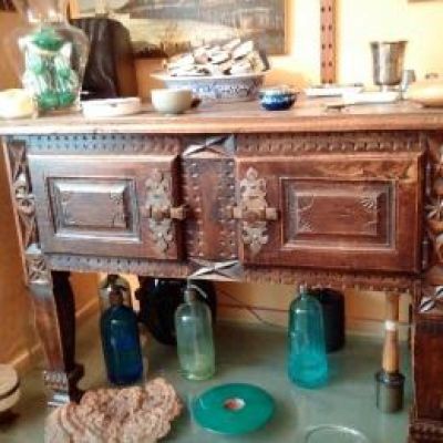 a wooden cabinet with glass bottles on the floor