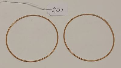 une paire de boucles d'oreilles en or sur fond blanc