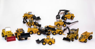 de nombreux engins de chantier miniatures posés sur une surface blanche