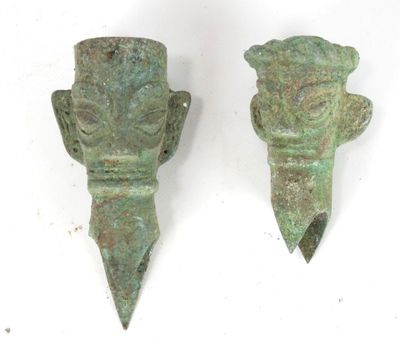 paire de sculptures anciennes représentant des têtes en bronze sur fond blanc