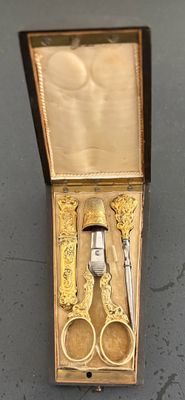 une boîte avec une paire de ciseaux et une paire de ciseaux à l'intérieur