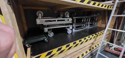 un homme qui se tient à côté d'une étagère sur laquelle est posé un train