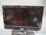 un petit téléviseur posé sur un meuble, sur une surface blanche