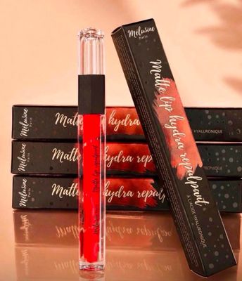 three lipsticks are sitting on a table next to a box of lipstick