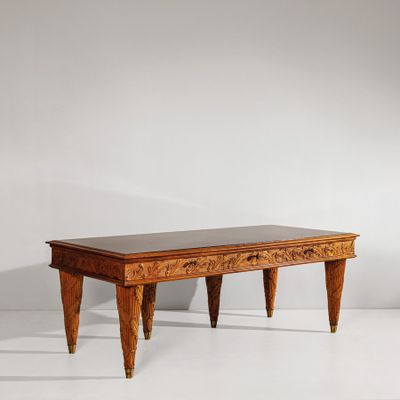 une table en bois à deux pieds, avec un plateau noir posé sur une surface blanche