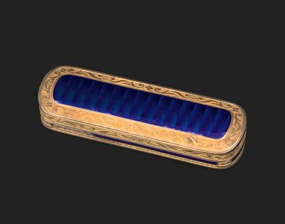 une boîte en verre bleu et or sur fond noir