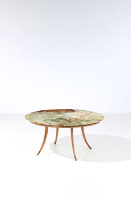une table avec un plateau en marbre et des pieds en bois, posée sur un plan de travail blanc