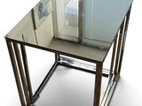 une table en verre avec une base en métal et un plateau en verre