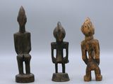 three wooden figurines of different shapes and sizes sitting next to each other