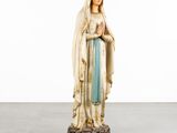 a statue of a woman in a blue dress holding a rosary