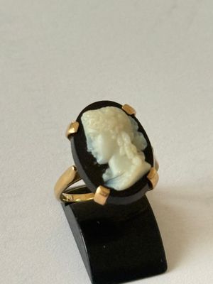 Bague en or jaune 750°/000 ornée d'un camée sur fond noir.