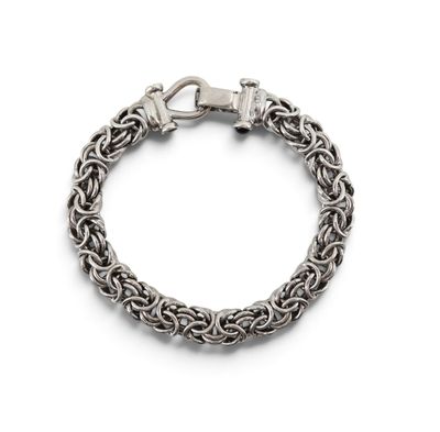 un gros plan d'un bracelet à maillons sur fond blanc