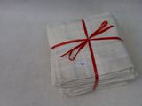 a stack of white napkins tied with a red ribbon