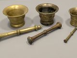 several brass objects are sitting on a table with a white background