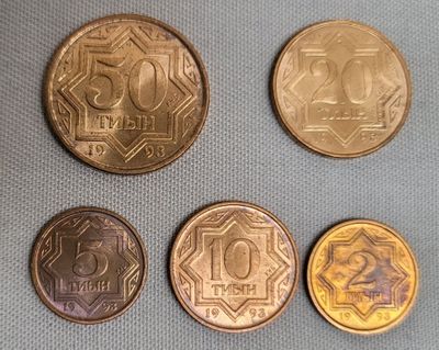 four different types of coins are shown on a blue surface