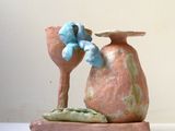 un petit vase surmonté d'un oiseau bleu