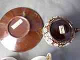 a cup and saucer sitting on a table next to a plate