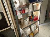 a man that is standing in a bathroom next to a shelf