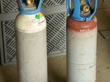 deux bouteilles de gaz posées l'une à côté de l'autre sur le sol