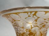 a glass vase with a gold and white design on it