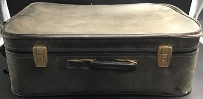 un bagage posé sur une table, avec une chaise en arrière-plan