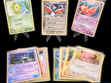 Plusieurs cartes Pokémon sont disposées en rangée sur un fond noir.