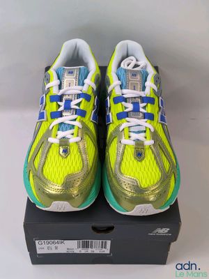 a pair of yellow and blue running shoes on top of a box