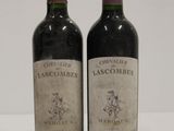 two bottles of red wine sitting next to each other on a table