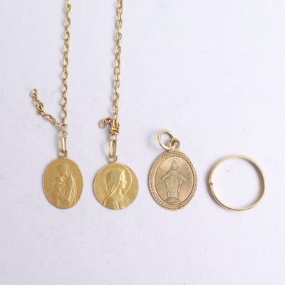 three gold coin necklaces and a gold ring on a white surface