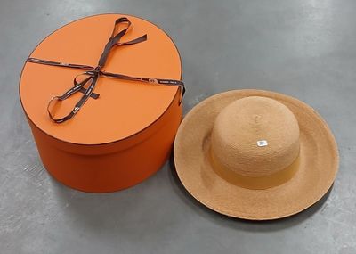 une boîte orange avec un chapeau et une paire de ciseaux