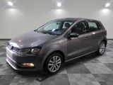 une Volkswagen Polo break grise garée dans une pièce au sol carrelé