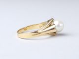 an image of a gold ring with a pearl in the middle