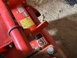 a red machine that is sitting in the dirt