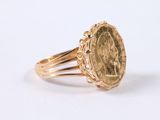 an image of a gold ring with a coin in the middle