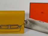 un petit sac à main jaune avec une anse argentée et un tissu