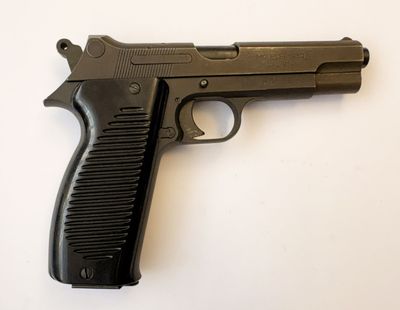 un pistolet posé sur une surface blanche
