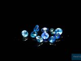 a group of blue sapphires sitting on top of a black surface