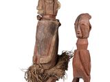 two wooden figurines of a man and a woman standing next to each other