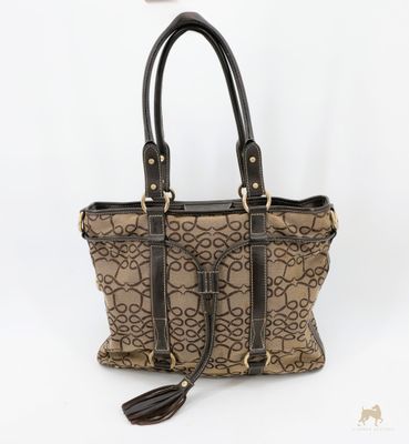 un sac à main marron et noir posé sur une surface blanche