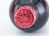 a close up of a wine bottle with a red cap