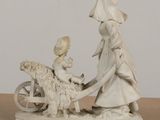 a figurine of a boy and a girl on a horse and cart