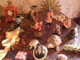 many figurines sitting on a table with a clock in the background
