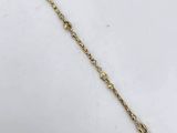 a close up of a gold chain bracelet with a heart on it