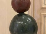 a sculpture of a ball sitting on top of a rock