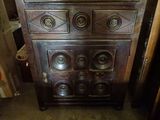 a wooden chest of drawers with a clock on top of it